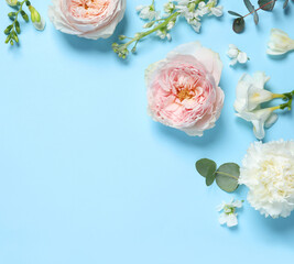 Flat lay composition with different beautiful flowers on light blue background. Space for text