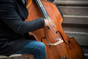 Closeup of musician playing with contrabass in the street
