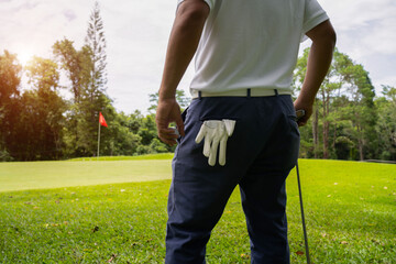 man white shirt blue pants In the hand holding a golf ball, prepare to play the next golf shot.