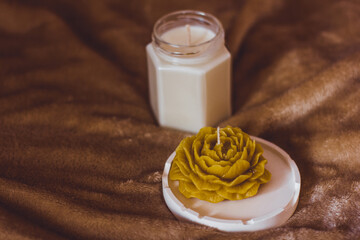 A candle in the shape of a flower. Beautiful handmade candles. Cozy atmosphere in the house
