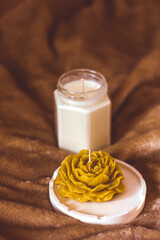 A candle in the shape of a flower. Beautiful handmade candles. Cozy atmosphere in the house