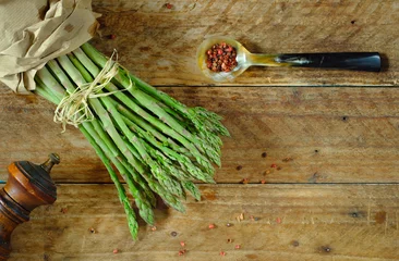 Fototapeten bunch of fresh green asparagus on wooden background, seasonal food and healthy eating © Kirsten Hinte