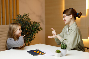 Deaf little girl talking to teacher in sign language, funny conversation.