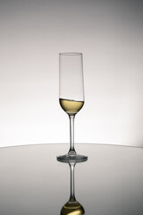 Glass of white wine with the reflection on table