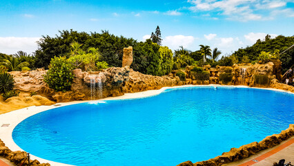 Beautiful shot of a swimming pool with water falls and man-made rock formations around