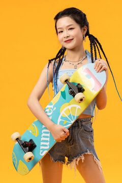 Personality young girl holding skateboard