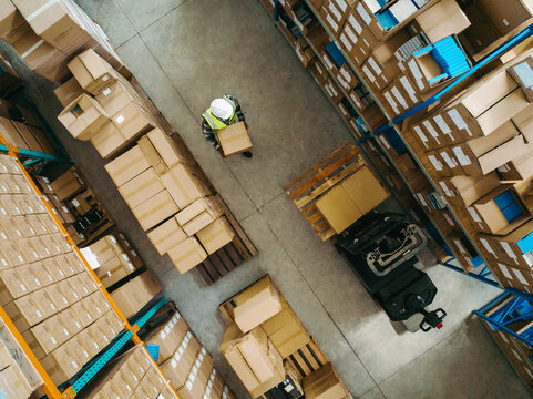 Aerial view of a warehouse worker carrying a package box