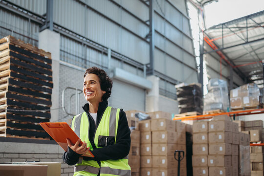 Mature warehouse manager smiling while holding a file