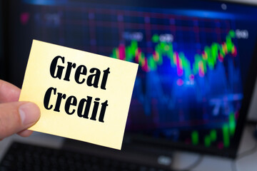 Male hand holding sticky note written Great Credit.