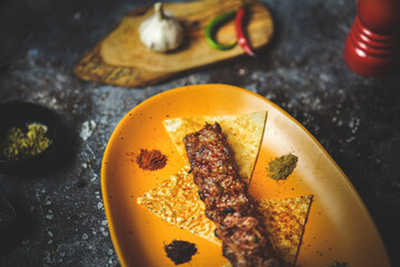 Stunning kebab presentation, vibrant yellow plate, mouthwatering dish, close-up, colorful,...
