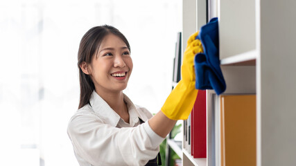Housewife in apron wearing gloves to using microfiber fabric to