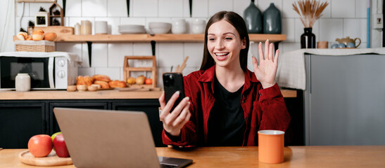 Young businesswoman using smartphone to video conference and gre