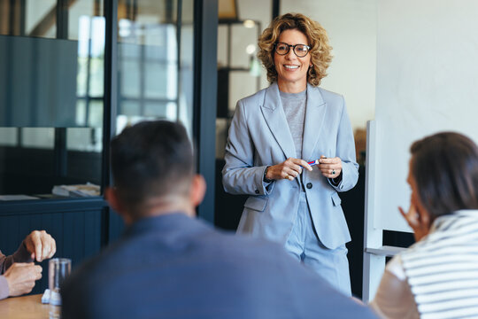 Mature business woman having a discussion with her team. Woman leading a meeting in an office