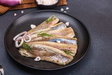 Fillet of pickled marinated sea herring fish with shallots and dill. Cutlery, vintage napkin
