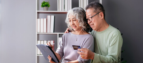 Senior couple using digital tablet and credit card to buying lif