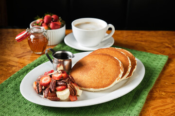Closeup shot of the perfect breakfast with homemade pancakes, fruits and a cup of coffee