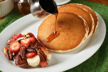 Closeup shot of a delicious breakfast with pancakes, strawberries and bananas