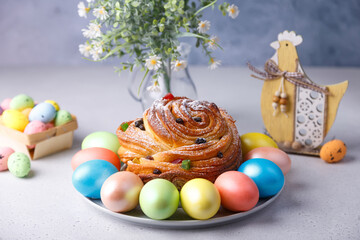 Craffin (Cruffin) with raisins and candied fruits sprinkled with powdered sugar. Traditional Easter Bread Kulich and painted eggs on a gray background. Easter Holiday. Close-up, selective focus.