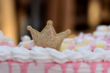 Closeup shot of a sparkly gold crown decoration on a cake