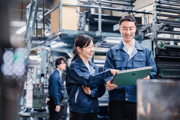 タブレットを見ながら工場で議論をするスタッフ