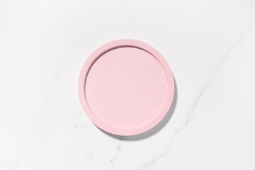 Beauty cosmetics product presentation flat lay mockup scene with pink circle shape on white marble table with copy space. Trendy sunlight,  top view. Studio photography.