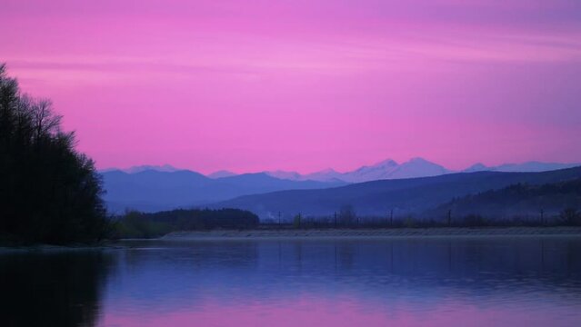 Scenic view of the pink sunset above the lake in Valcelele, Romania