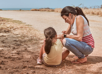 mother and daughter walking along wild roads, trails and the shores of a beach. Urban hikers walking along a mountain path along the shoreline of a beach, watching the sea, collecting rocks, interacti