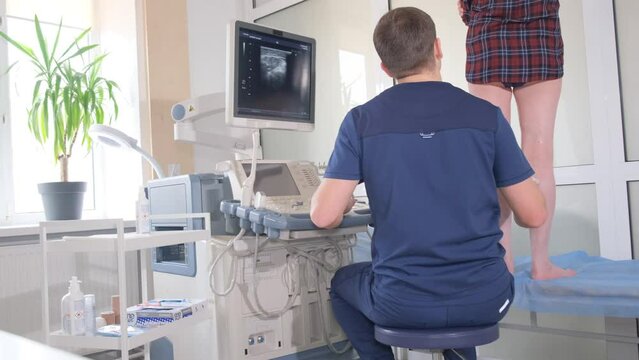 The doctor diagnoses the veins on the legs with the help of ultrasound diagnostics. 