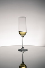 Glass cup of wine with reflection on a mirror surface