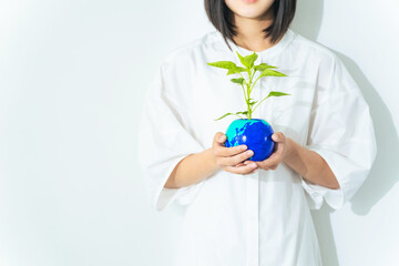 地球の描かれた植木鉢を持つ女の子　環境保護イメージ
