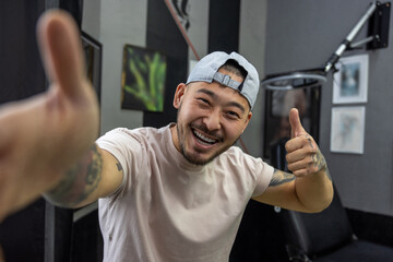 Naklejka premium Asian young man in a tattoo salon