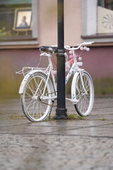 Rower różowy przy lampie w deszczu