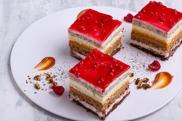 Appetizing dessert with slices of cakes with raspberry and nuts