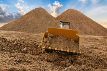 Wheel loader are digging the soil in the construction site with a sky background.