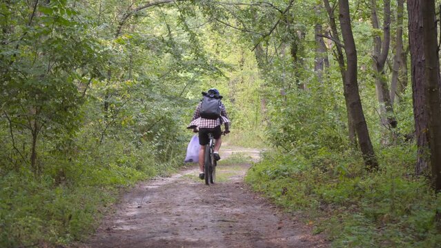 Pollution. Ecological problem. Male cyclist carry garbage bag on handlebars bicycle after removing pollution. Male collects garbage during eco marathon, cleaning plastic bottles and other garbage.