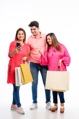 Indian people group holding shopping bags and using smartphone on white background.