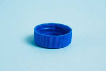 Plastic cap from a bottle on a blue background. Concept for earth and zero waste