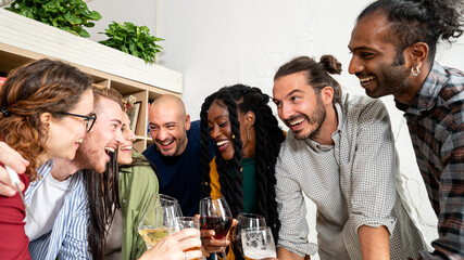 Happy friends drinking beers and wine, celebrating event at restaurant, multiracial people having fun together