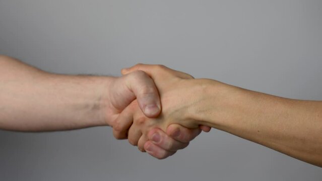 Man and woman handshake, grey background
