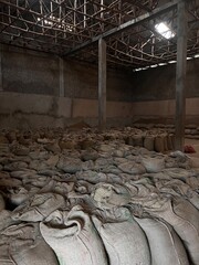 stock of green coffee beans in large canvas bags stored in a warehouse in the Sidama region of...