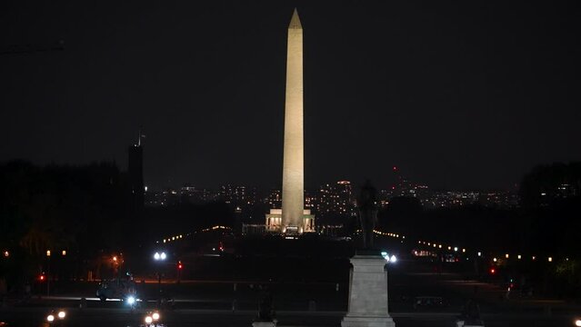 Washington Monument and Lincoln Memorial as seen from the US Capitol at night in Washington, DC with twinkling lights of traffic.