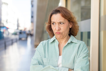 middle age woman feeling displeased and disappointed, looking serious, annoyed and angry with crossed arms