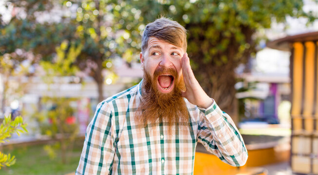 red hair bearded man profile view, looking happy and excited, shouting and calling to copy space on the side