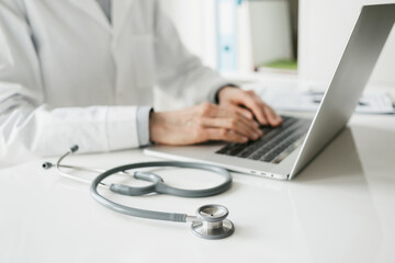 Doctor medical professional working on laptop, Physician, therapist or practitioner filling medical documents, writing prescription for patient. Health care, medicine concept