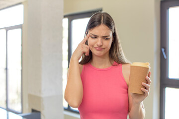 young pretty woman looking surprised, realizing a new thought, idea or concept. take away coffee concept