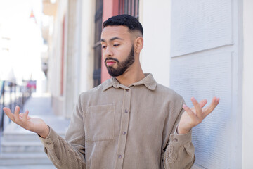 young handsome man feeling puzzled and confused, unsure about the correct answer or decision,...