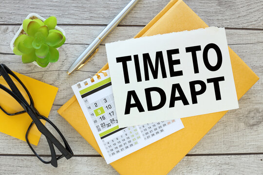 TIME FOR ADAPT. torn page with text and a calendar on a yellow notepad. Concept for management and business.