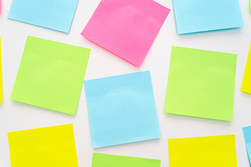 Post it of various colors stuck to a white surface. Notes and memos.