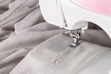 Modern sewing machine presser foot with linen fabric and thread, closeup. Sewing process clothes,...