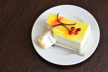 A piece of creamy cake with a piece of fruit and chocolate on it 